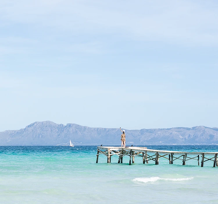 mujer fotografiando la playa desde el pantalán de Playa de Alcúdia